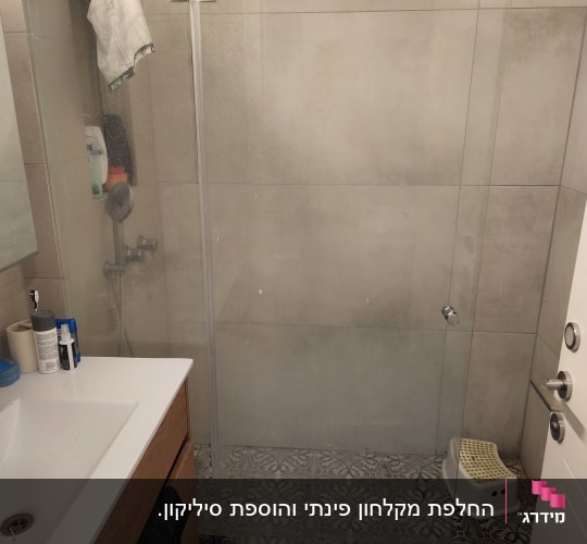 מקלחון זכוכית עם ראש מקלחת ומוצרים לטיפוח